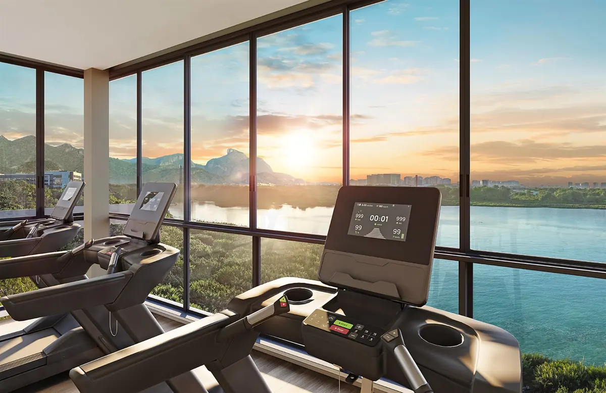 Glazed gym at Breeze Inspire Residence, with treadmills facing the lagoon view