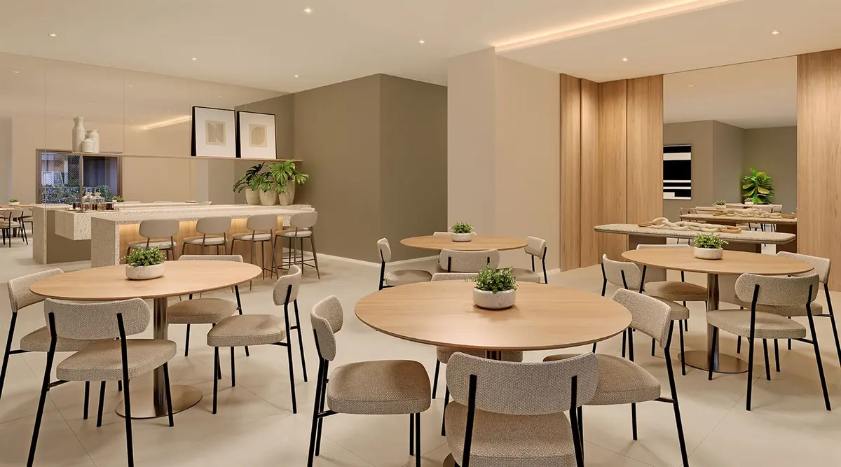 Party room at Breeze Inspire Residence, with round tables and a service kitchen