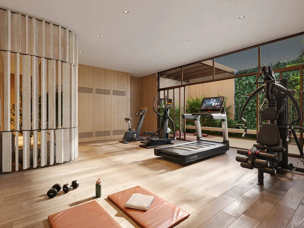 Academia do Espaço Wellness, com equipamentos e iluminação natural vinda do jardim