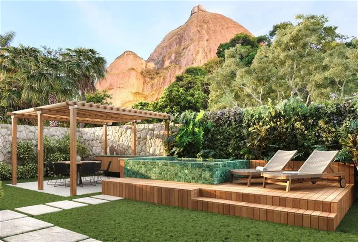 Garden privativo de townhouse do Vista Joá, com espreguiçadeiras, pergolado e a Pedra da Gávea ao fundo